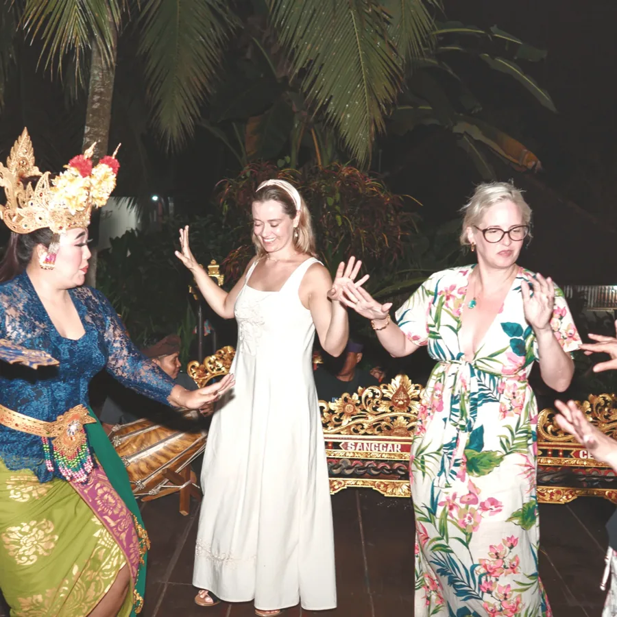Guests dancing with a traditional dancer at night