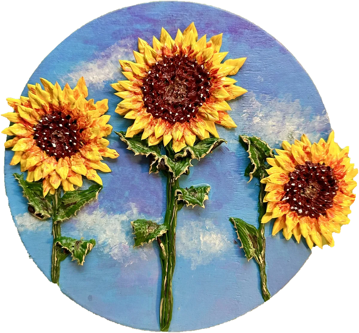 Round panel of three sculpted sunflowers against a blue sky